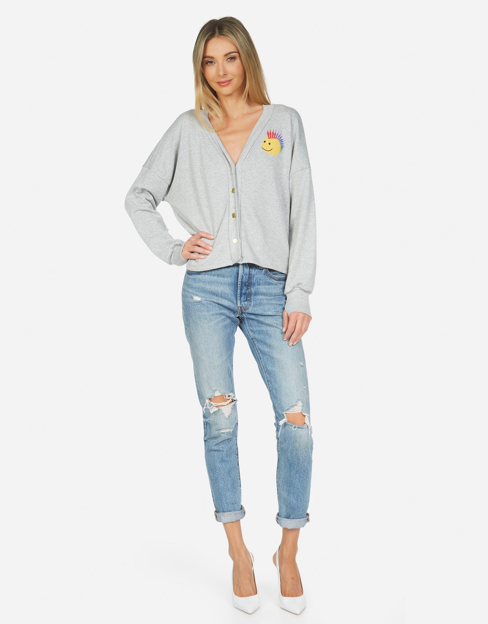 light grey cardigan with ripped jeans, pumps, blonde woman, and a mohawk smiley face